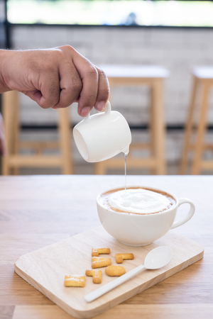pouring syrup in to Latte hot coffee cupの写真素材