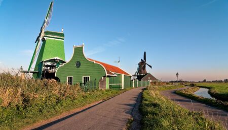 Row of Zaanse Schans Windmill in the morning near a small curvy riverの写真素材