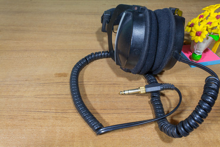 Beautiful leather black headphones  on wood backgroundの写真素材