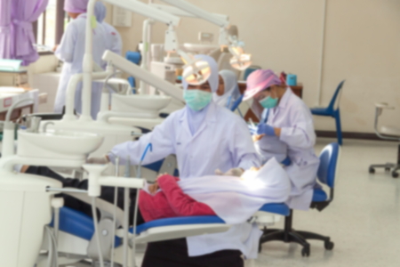 Blur blurred Dental students to practice Treated patients. in dental hospital on patient's tooth care using equipment, instrument on dental chairの写真素材