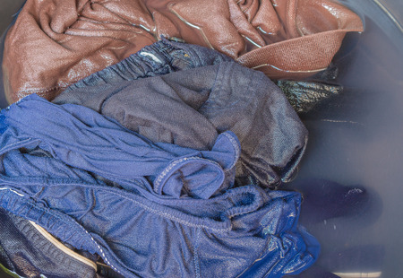 Close up Soak dirty clothes in the basin black for cleanse,Thailand washing clothes style ancient and soaking with detergent.の写真素材