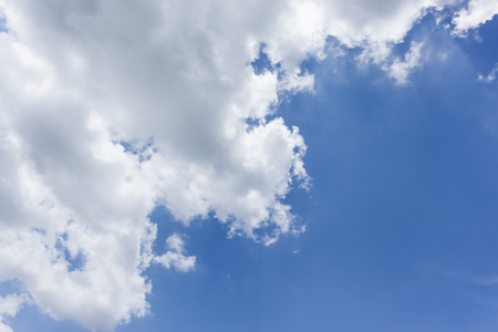 Blue sky is covered by white clouds and raincloud (may be used as background)の写真素材