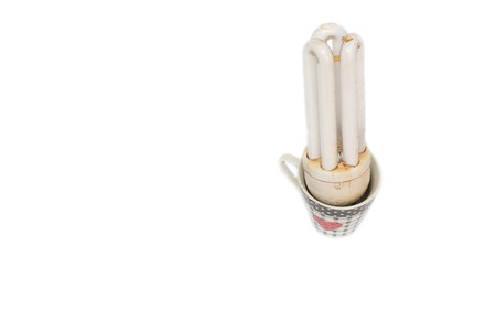 Old Energy saving light bulb in the glass. Long used  light bulb,  On a white background.の写真素材