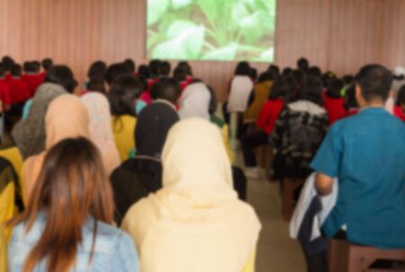 Blurred abstract background of university students sitting in a lecture room with  Movie screen , education high school, technology and people concept: Blurry view from back of the classroom:の写真素材
