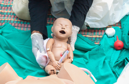 Doctor, paramedic,  The refresher training to assist childbirth newborn with medical baby dummy in emergency the midwife.(select focus baby dummy)の写真素材