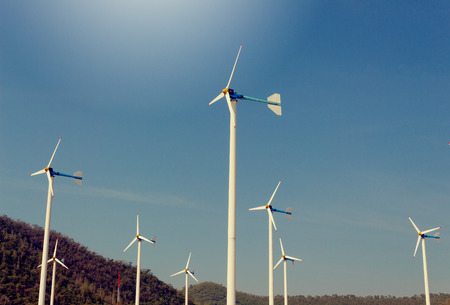 Wind Turbine for alternative energy, on background Sky and Mountain.