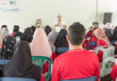 Blurred abstract background of university students sitting in a lecture room with teacher of the out Community education: Blurry view from back of the classroom: Teachers dayの写真素材