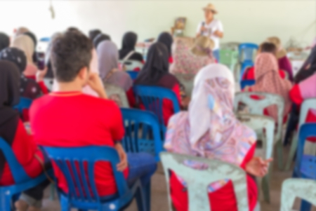 Blurred abstract background of university students sitting in a lecture room with teacher of the out Community education: Blurry view from back of the classroom: Teachers dayの写真素材