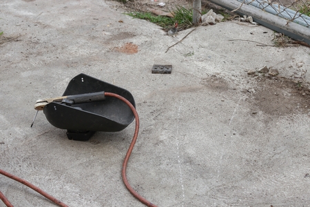 welding mask, still life of rod-holder with cable and electrode, for electric arc welding, on a...