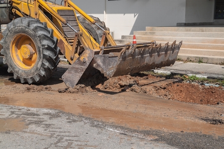 Excavator working on the Repair of pipe water and sewerage on road, Worker using a small excavator...