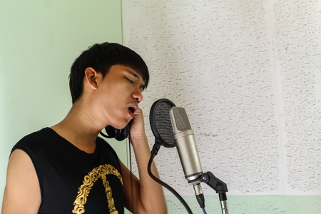 microphone, in recording studio microphone condenser, handsome man Asian professional musician recording  :select focus front microphone condenser and soft-focus Young male:の写真素材