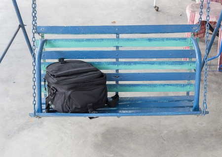 Bag Black on Porch swings, Beautiful black camera bag Located on wooden front porch swing : select focus Bag Black :の写真素材