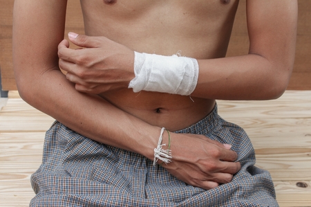 Bandage elastic. Pain and injury concept. Young man holds bandaged hand. Injured part of body. Medicine and healthcare.の写真素材