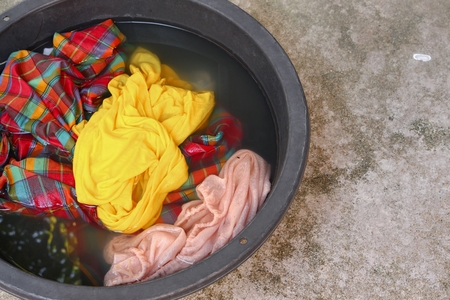 Soak dirty clothes in the basin black for clean ,Thailand washing clothes style ancient and soaking with detergent. :Close up,select focus with shallow depth of field. :の写真素材