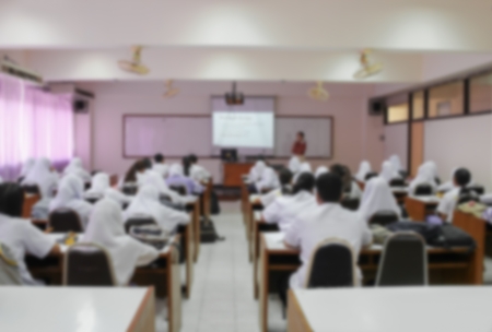 students sitting in a lecture room with the teacher in front of the class with white projector slide screen : Blur blurred abstract background of view from back of the classroom: Teachers dayの写真素材