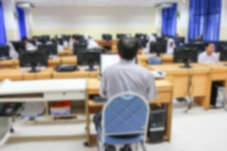 Student with teacher and desktop computer. Abstract Blur blurred technology students group learning in computer lab room education.の写真素材