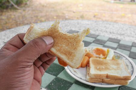 Bread slices and jam in hand Close upの写真素材