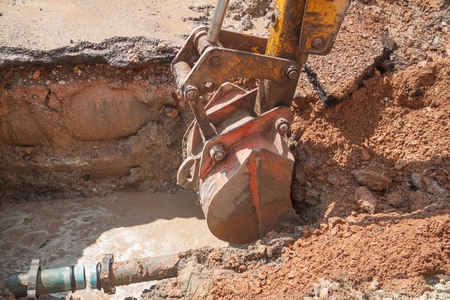 Excavator, bulldozer work a hole the repair of pipe water and sewerage on road