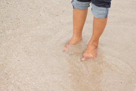 barefoot legs walking in the seashore, Vacation on summer sea beachの写真素材