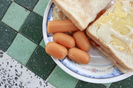 toast breakfast with fried eggs and sausages on stone table:Close up,select focus front toast and soft-focus background.の写真素材
