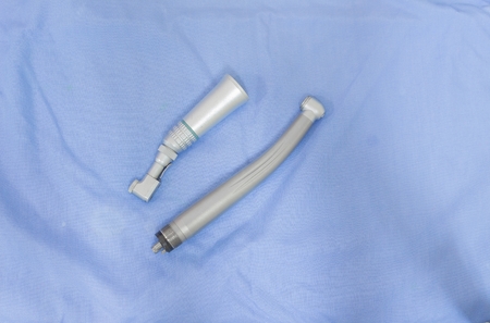 Dental turbine or drill, dentist tool specialized equipment to treat on blue fabric