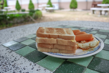 toast breakfast with fried eggs and sausages on stone table:Close up,select focus front toast and...