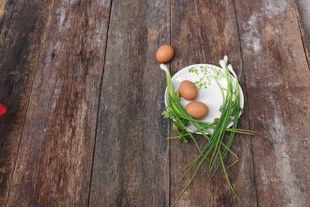 fresh chicken egg on a plate  and onion in wooden table, Top view with copy spaceの写真素材