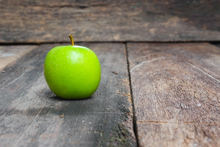 Green apple on wooden table  background, close up select focus with shallow depth of field.の写真素材
