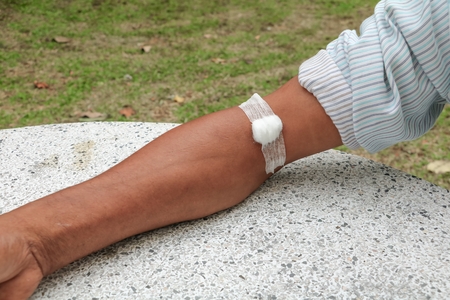 Bandage and gauze on an arm after a blood test :Select focus with shallow depth of field.の写真素材