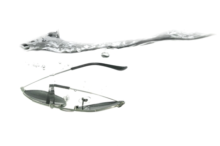 glasses fall in water splash bubbles show motion on white background, with copy space.の写真素材