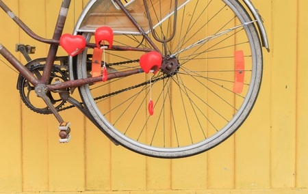 Vintage rear wheel for bicycle old style rusty on yellow wall  wood background.の写真素材