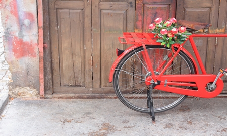 flower on saddle red bicycle classic vintage on wall wood background with copy space for add textの写真素材