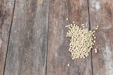 dry sugar pea seed, green nuts on the wood board background. Top viewの写真素材