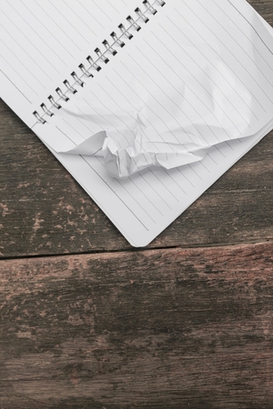 notebook crumpled  on wooden table, business conceptの写真素材