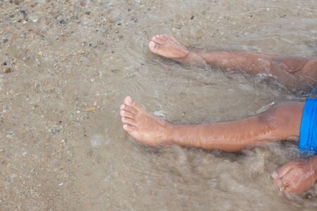 foot of child in sea at motionの写真素材
