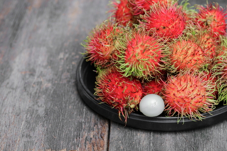 rambutan sweet fruit fresh in plate on wood background :Select focus with shallow depth of field.の写真素材