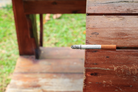 Cigarette burn selective focus on a wooden table  at hazard Healthの写真素材