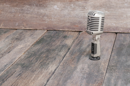 Retro microphone. Vintage style on the wooden floor background  :Select focus with shallow depth of field.の写真素材