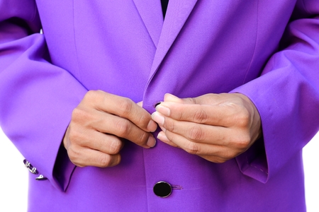 Handsome elegant young fashion man in suit purple with fasten the button on white background