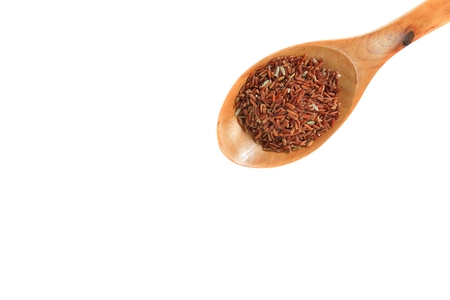 brown rice in wood spoon Close up on white backgroundの写真素材