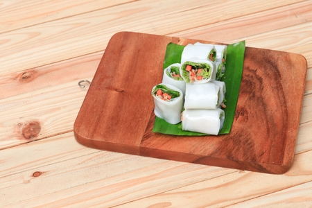 spring roll with vegetable on banana leaf wood floor backgroundの写真素材
