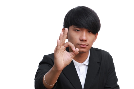 Happy young businessman showing ok sign on white backgroundの写真素材