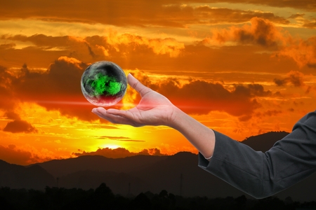 business man receiving hand holding the world in  palm of  idea  on sky red  backgroundの写真素材