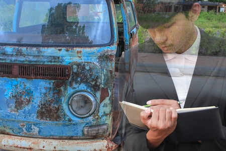 businessman  with notepad  hand signing documents in garage,double exposure concept .の写真素材