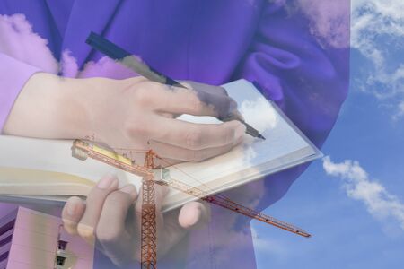businessman  with notepad in hand signing documents   in construction  site workplace, double exposure concept.の写真素材