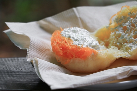 bread stuffed in paper napkin on a wooden table