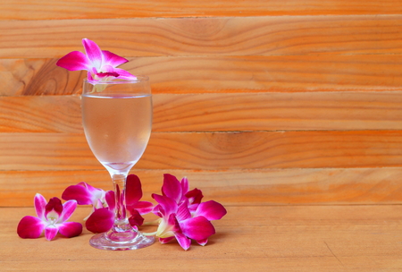 water glass cool with orchid purple  on wooden floor board with copy space add textの写真素材