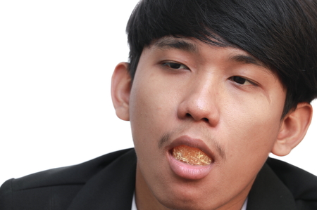 handsome man eating a fresh orange on white backgroundの写真素材