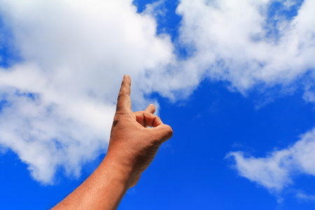 hand pointing or touching to something on  blue sky backgroundの写真素材