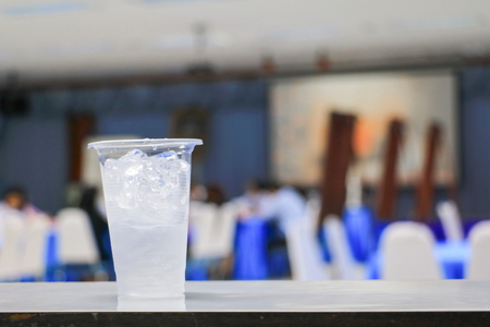 ice water in glass-plastic in seminar conference room background. select focus with shallow depth of fieldの写真素材